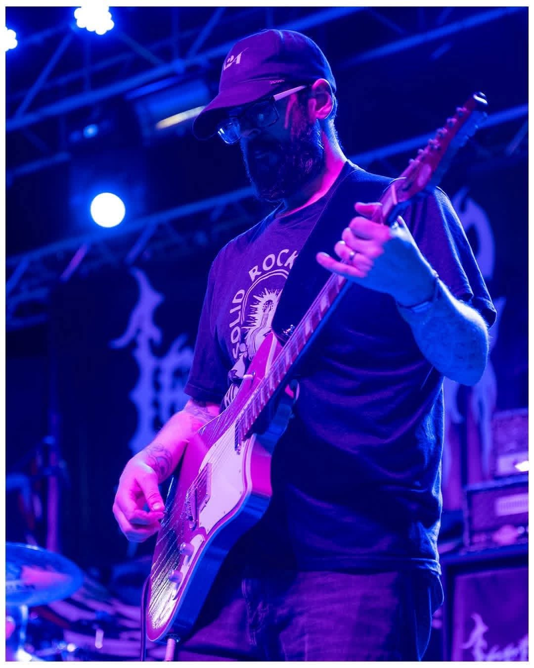 Penumbra guitarist performing live with electric guitar under blue and magenta lights